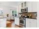 Open kitchen featuring white cabinetry, stainless appliances, granite countertops, and hardwood flooring at 188 Donning Dr, Summerville, SC 29483