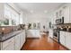 Open kitchen featuring granite countertops, white cabinetry, stainless appliances, and hardwood flooring at 188 Donning Dr, Summerville, SC 29483