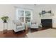 Bright living room with two light blue chairs, dark wooden floors, and a fireplace at 188 Donning Dr, Summerville, SC 29483