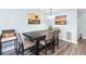 Dining area with seating for six, complemented by coastal artwork and a charming chandelier, creates a cozy space at 1919 Marsh Oak Ln, Seabrook Island, SC 29455