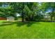 Lush backyard featuring a well-maintained lawn, mature trees, a storage shed and privacy fence at 2026 Thornhill Dr, Summerville, SC 29485