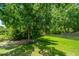 Secluded backyard with a lush lawn, mature trees offering ample shade, and a classic white picket fence at 2026 Thornhill Dr, Summerville, SC 29485