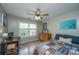 Comfortable bedroom with a wooden dresser, desk, ceiling fan, and plenty of natural light at 2026 Thornhill Dr, Summerville, SC 29485
