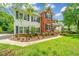 Charming two-story home with a lush green lawn and colorful flowerbeds under a blue sky at 2026 Thornhill Dr, Summerville, SC 29485