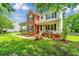 Charming two-story home with a lush green lawn, flowerbeds, and front porch with stairs at 2026 Thornhill Dr, Summerville, SC 29485