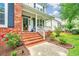 Inviting front porch with brick steps, a white railing, and views of the landscaped yard at 2026 Thornhill Dr, Summerville, SC 29485