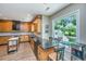 Well-lit kitchen with wood cabinets, granite countertops, and a view of the backyard at 2026 Thornhill Dr, Summerville, SC 29485