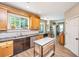 Bright kitchen featuring wood cabinets, stainless steel appliances, dark countertops, and a mobile island at 2026 Thornhill Dr, Summerville, SC 29485