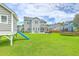 Large backyard featuring a playhouse, slide, and trampoline at 207 Center Hill Ct, Summerville, SC 29485