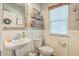 A charming powder room featuring a pedestal sink, decorative mirror, and wainscoting detail at 207 Center Hill Ct, Summerville, SC 29485