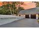A well-maintained backyard with a pool, a two car garage, and a white picket fence at dusk at 2142 Golfview Dr, Charleston, SC 29412