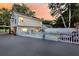 A beautiful backyard with a pool, white picket fence and an outdoor seating area at dusk at 2142 Golfview Dr, Charleston, SC 29412
