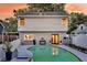 Backyard pool surrounded by a concrete patio, gray house, white fence, and beautiful landscaping at 2142 Golfview Dr, Charleston, SC 29412