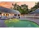 Stunning backyard pool featuring well-manicured landscaping, dark garage doors, and white picket fence at 2142 Golfview Dr, Charleston, SC 29412