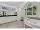 Elegant bathroom featuring a soaking tub, white cabinets, and a large arched window at 2142 Golfview Dr, Charleston, SC 29412