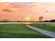 Beautiful golf course view with a paved path, pond, and a scenic sunset backdrop at 2142 Golfview Dr, Charleston, SC 29412