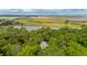 An aerial view of a house surrounded by lush trees, golf course, marsh and bridge at 2217 Ramsay St, Charleston, SC 29412