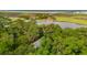 Aerial view showing the home surrounded by lush greenery, a body of water and a bridge in the distance at 2217 Ramsay St, Charleston, SC 29412