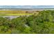 An aerial view of a house surrounded by lush trees, golf course, and the marsh at 2217 Ramsay St, Charleston, SC 29412