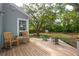 Inviting back deck with rocking chairs and beautiful, treed landscaping and outdoor fireplace at 2217 Ramsay St, Charleston, SC 29412