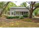 Home exterior featuring large yard with lush landscaping, mature trees and second story deck at 2217 Ramsay St, Charleston, SC 29412