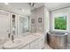 Stylish bathroom featuring double sinks, sleek soaking tub, and luxurious shower at 2217 Ramsay St, Charleston, SC 29412