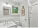 Well-lit bathroom featuring a vanity with marble countertop, toilet, glass-enclosed shower and window that offers a view of trees at 2217 Ramsay St, Charleston, SC 29412