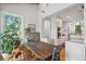 Light-filled dining area boasts hardwood floors, rustic table, and access to a modern white kitchen at 2217 Ramsay St, Charleston, SC 29412