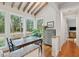 Bright dining area features wooden table, hardwood floors, large windows with nature views, and rustic ceiling beams at 2217 Ramsay St, Charleston, SC 29412