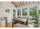 Light-filled dining area features rustic table, bench seating, hardwood floors, exposed ceiling beams, and scenic views at 2217 Ramsay St, Charleston, SC 29412