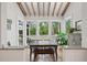 Open dining area with rustic table, bench seating, hardwood floors, exposed ceiling beams, and lots of natural light at 2217 Ramsay St, Charleston, SC 29412