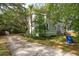 View of side yard with mature trees and large driveway with basketball court, attached to the home's exterior at 2217 Ramsay St, Charleston, SC 29412