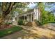 Charming gray home with inviting front porch, American flag, mature trees, and beautifully landscaped front yard at 2217 Ramsay St, Charleston, SC 29412