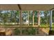 Covered porch with a tranquil view through the trees to the water beyond at 2217 Ramsay St, Charleston, SC 29412
