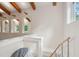 Bright staircase with a wooden handrail and metal supports. Windows bring natural light, with exposed ceiling beams above at 2217 Ramsay St, Charleston, SC 29412