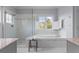Bright bathroom featuring a soaking tub, a glass-enclosed shower, and neutral color palette at 2489 Daniel Island Dr, Daniel Island, SC 29492
