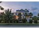 Charming two-story white home with lush landscaping, black iron fence, and a welcoming front porch at 2489 Daniel Island Dr, Daniel Island, SC 29492