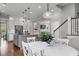 Open-concept kitchen with pendant lighting, an island with seating, and a view of the living room and stairs at 2489 Daniel Island Dr, Daniel Island, SC 29492