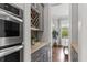 Butler's pantry featuring stainless steel appliances, a wine rack, granite countertops, and hardwood floors at 2489 Daniel Island Dr, Daniel Island, SC 29492