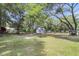 Expansive backyard with lush lawn, large trees, a swing, a charming shed, and space to play at 2631 Ridgewood Ave, Charleston, SC 29414
