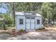 Backyard shed featuring an interesting roofline, double doors, and decorative windows at 2631 Ridgewood Ave, Charleston, SC 29414