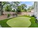 Private backyard featuring a putting green, lush landscaping, and a charming bench at 2666 Poplin Ave, North Charleston, SC 29405