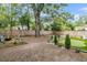 Spacious backyard with mature trees, a putting green, and comfortable seating area at 2666 Poplin Ave, North Charleston, SC 29405