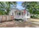 Charming home showcasing a cozy front porch, complemented by a manicured landscape and fresh, white paint at 2666 Poplin Ave, North Charleston, SC 29405
