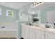 Well-lit bathroom with dual sinks, a large mirror, and a soaking tub at 2727 4 Winds Pl, Mount Pleasant, SC 29466