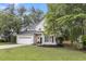 Two-story home featuring a two-car garage, manicured lawn, landscaping, and a cozy front porch at 2727 4 Winds Pl, Mount Pleasant, SC 29466
