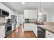 Modern kitchen with stainless steel appliances, white cabinetry, and beautiful hardwood floors at 2727 4 Winds Pl, Mount Pleasant, SC 29466