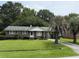 Charming one story brick home with mature landscaping, green lawn, and a paved driveway at 2734 Mona Ave, Charleston, SC 29414