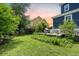 Large grassy backyard featuring a built-in fire pit, bench seating, and string lights near the home at 2981 Sturbridge Rd, Mount Pleasant, SC 29466