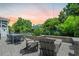 Backyard fire pit, lounge chairs and dining table surrounded by stone pavers and green landscaping at 2981 Sturbridge Rd, Mount Pleasant, SC 29466